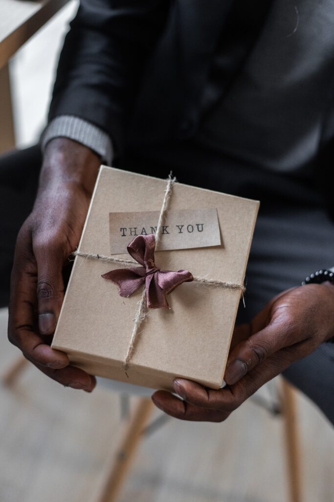 Man holding a gift box that says "Thank you"