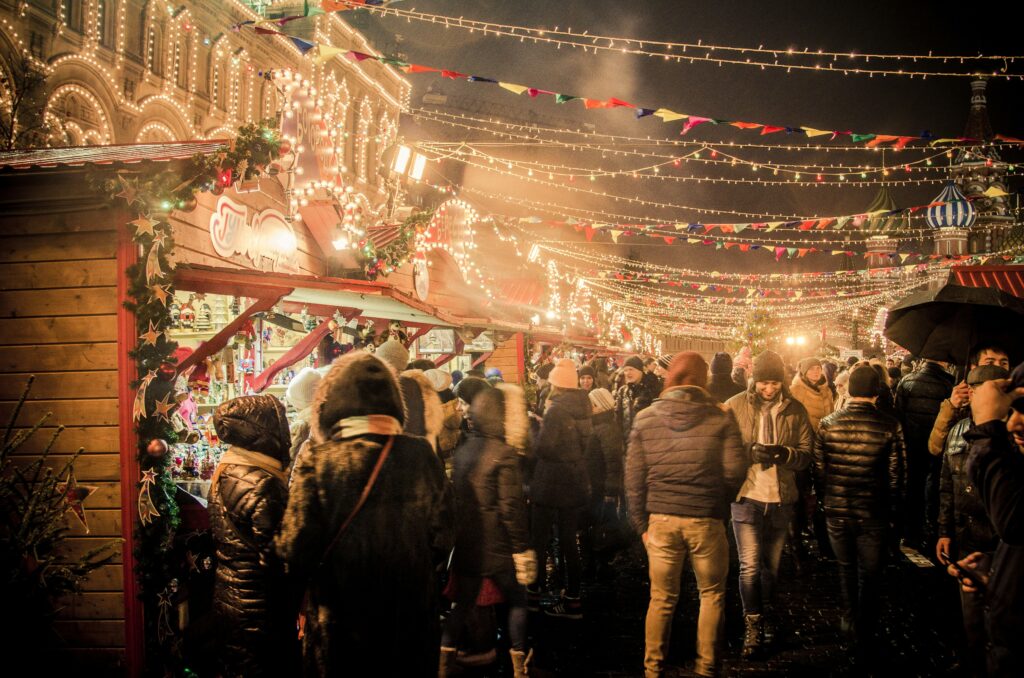 Christmas scene with lots of christmas lights & people walking around