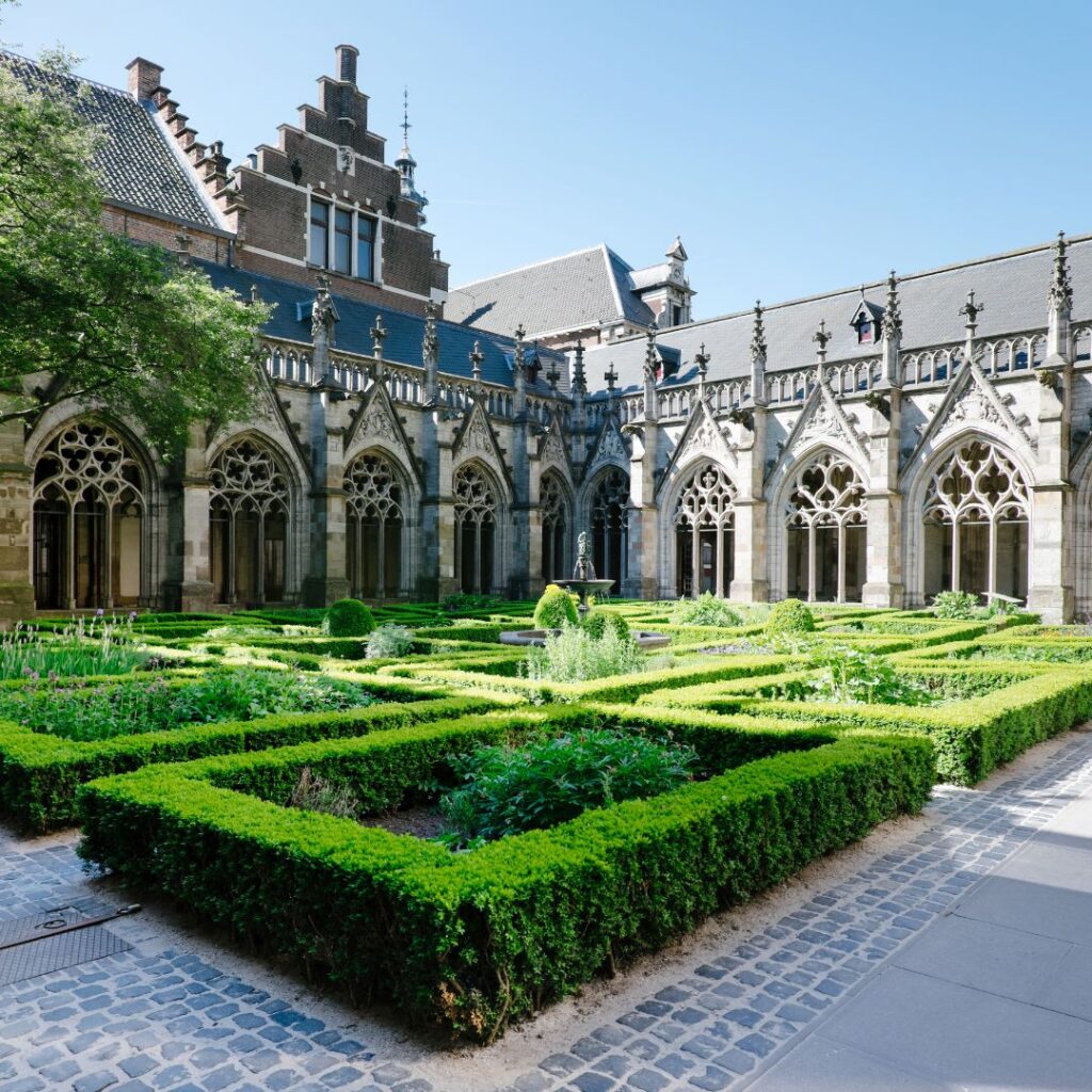A picture of a beautiful garden with perfect hedges in a place that looks like a royal palace in a trendy neighborhood in London.