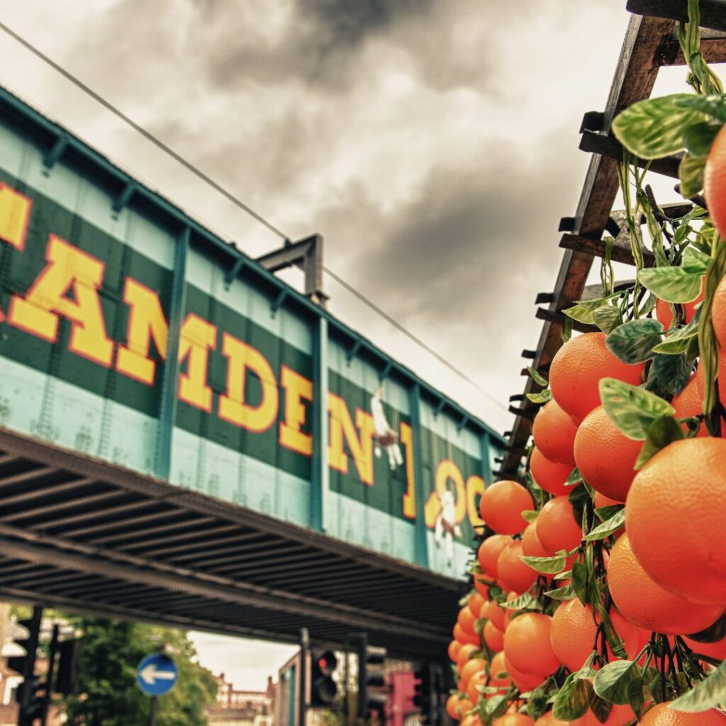 A bridge in Camden with oranges in front of it.;