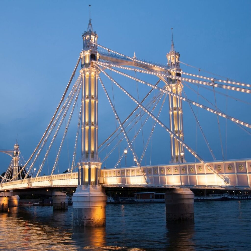 A picture of the Chelsea bridge right before it gets dark in one of the trendy neighborhoods of London.