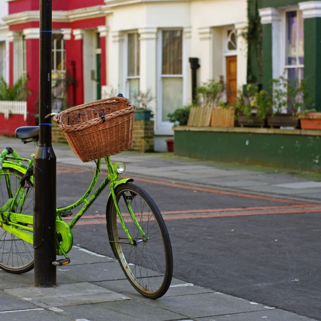 A street in Notting Hill with a bike leaned up against a light pole in a trendy neighborhood in London.