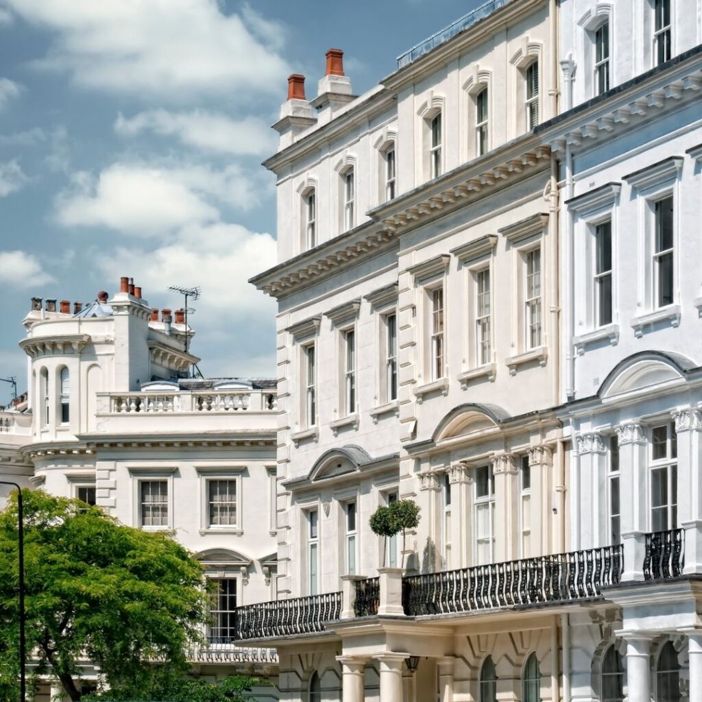 A white royal looking building in Nottinghill, which is a trendy neighborhood in London.