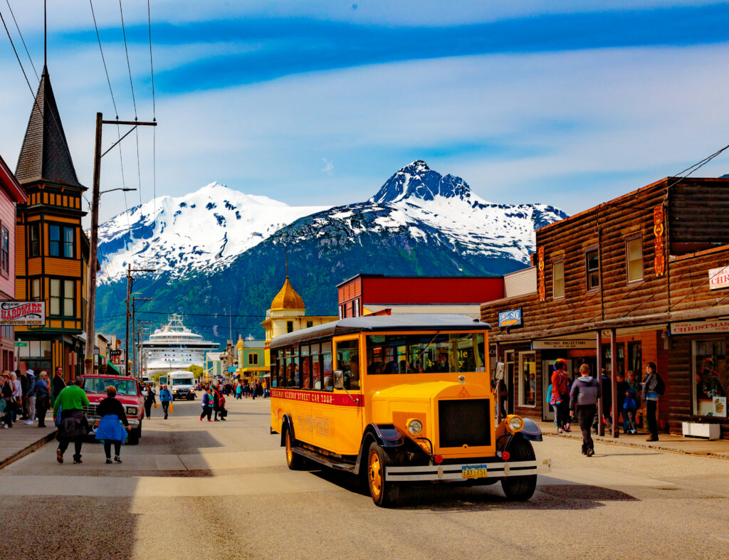 White Pass and Yukon Route Railroad narrow gauge train winding through snow capped mountain scenery near Skagway Alaska