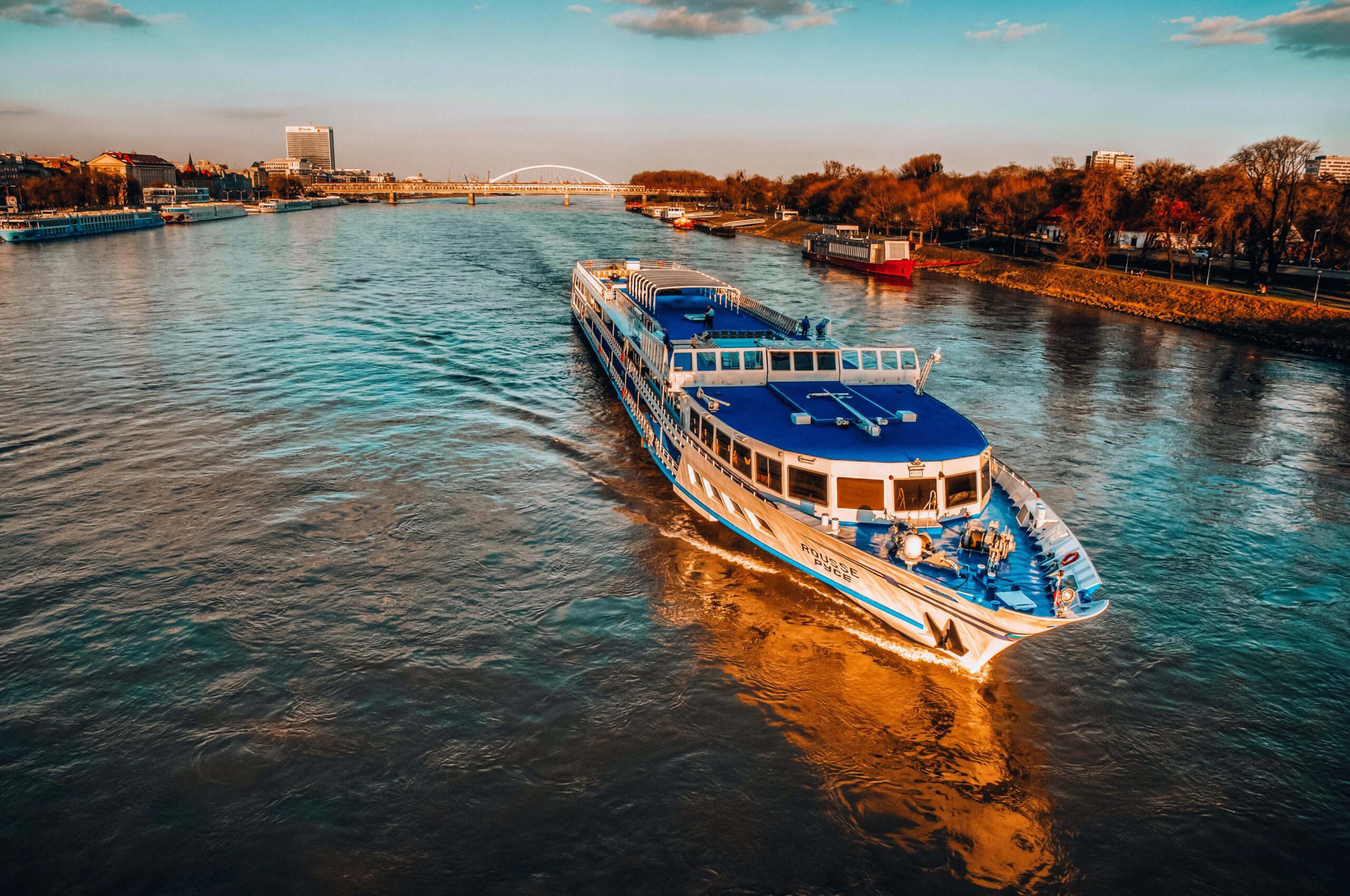 European river cruise for couples on the Rhine River with medieval castle and vineyards on the riverbank at sunset
