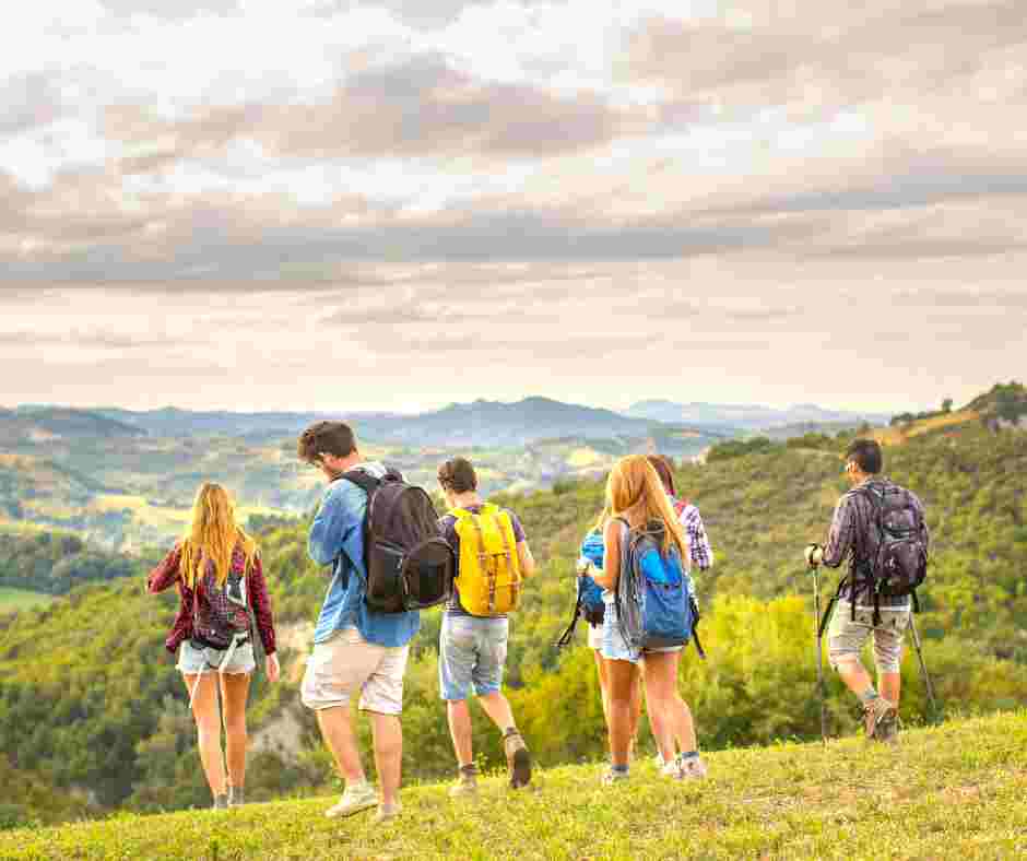 Group of travelers walking along a scenic Irish coastal path with dramatic cliffs and green landscape on a guided Ireland group tour.