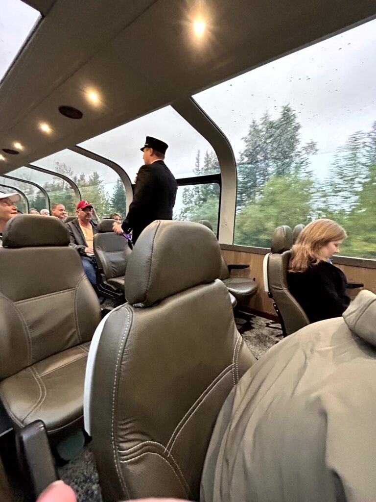 Glass dome railcar with conductor narrating the route to Talkeetna