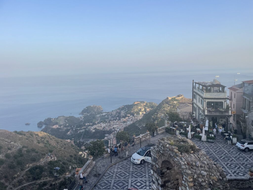 Slow travel in Italy: the view over Taormina and the coast from Castelmola, Sicily (featured)